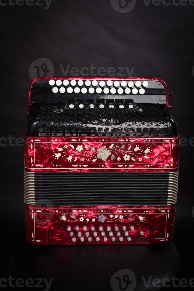 Russian folk instruments.Red bayan on a black background.Russian accordion photo