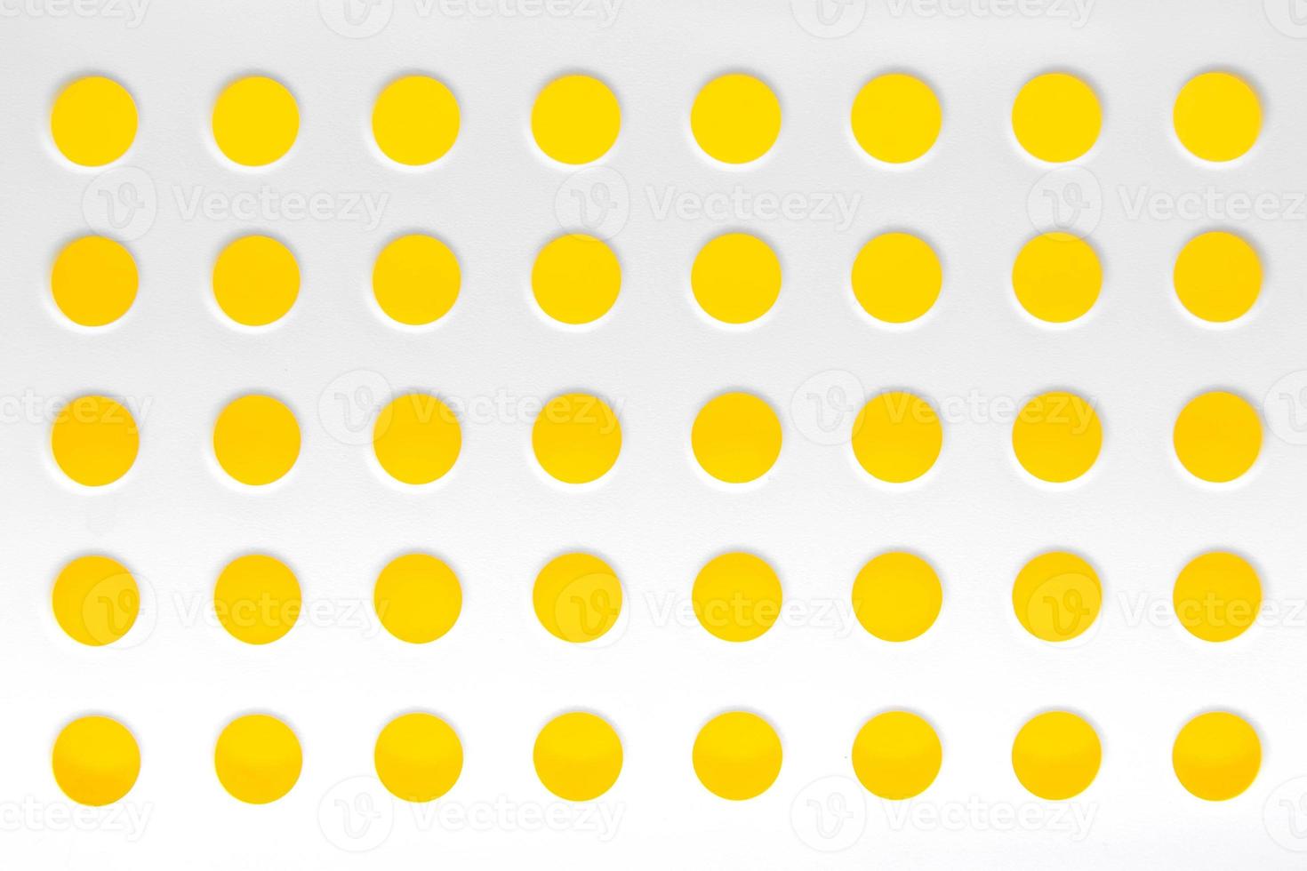 White plastic background with regular holes on yellow background. Copy, empty space for text photo