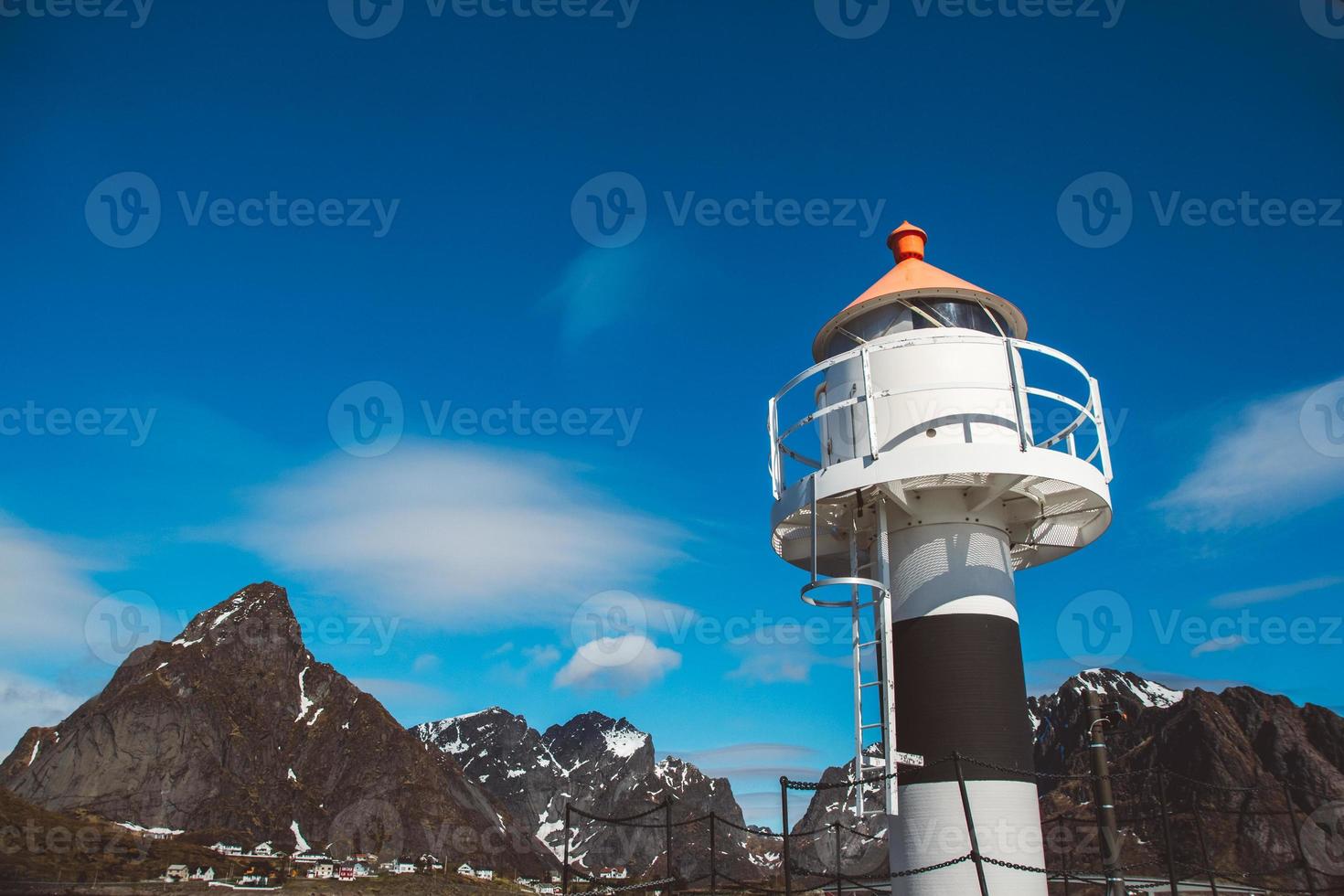 Lighthouse on the pier on the background of the mountains and the blue sky on the Lofoten Islands. Place for text or advertising photo