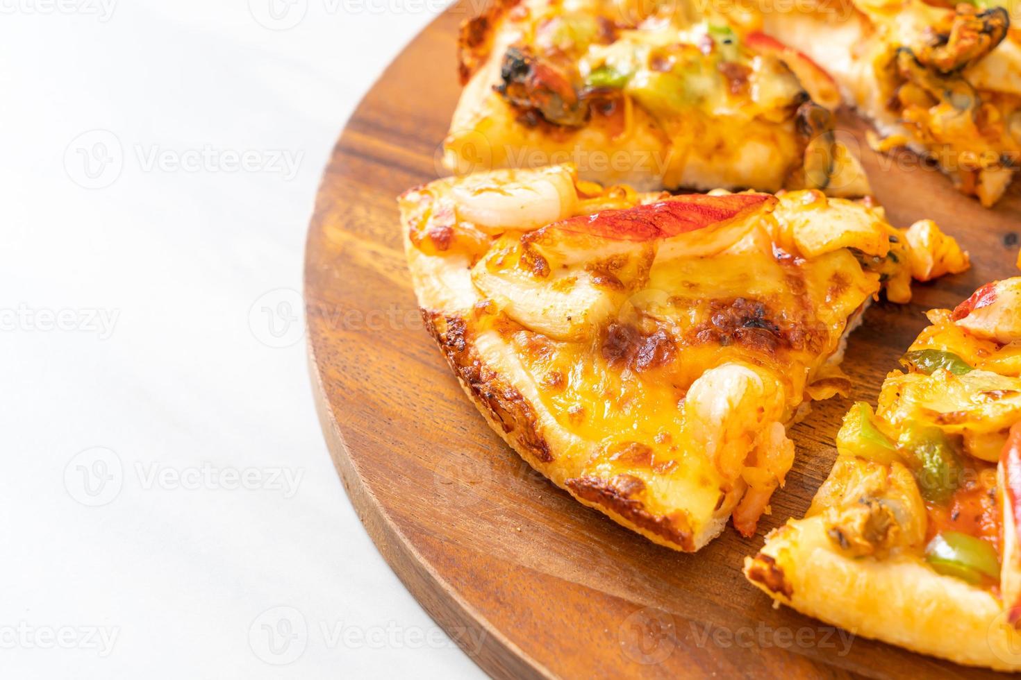 Pizza de mariscos en bandeja de madera foto