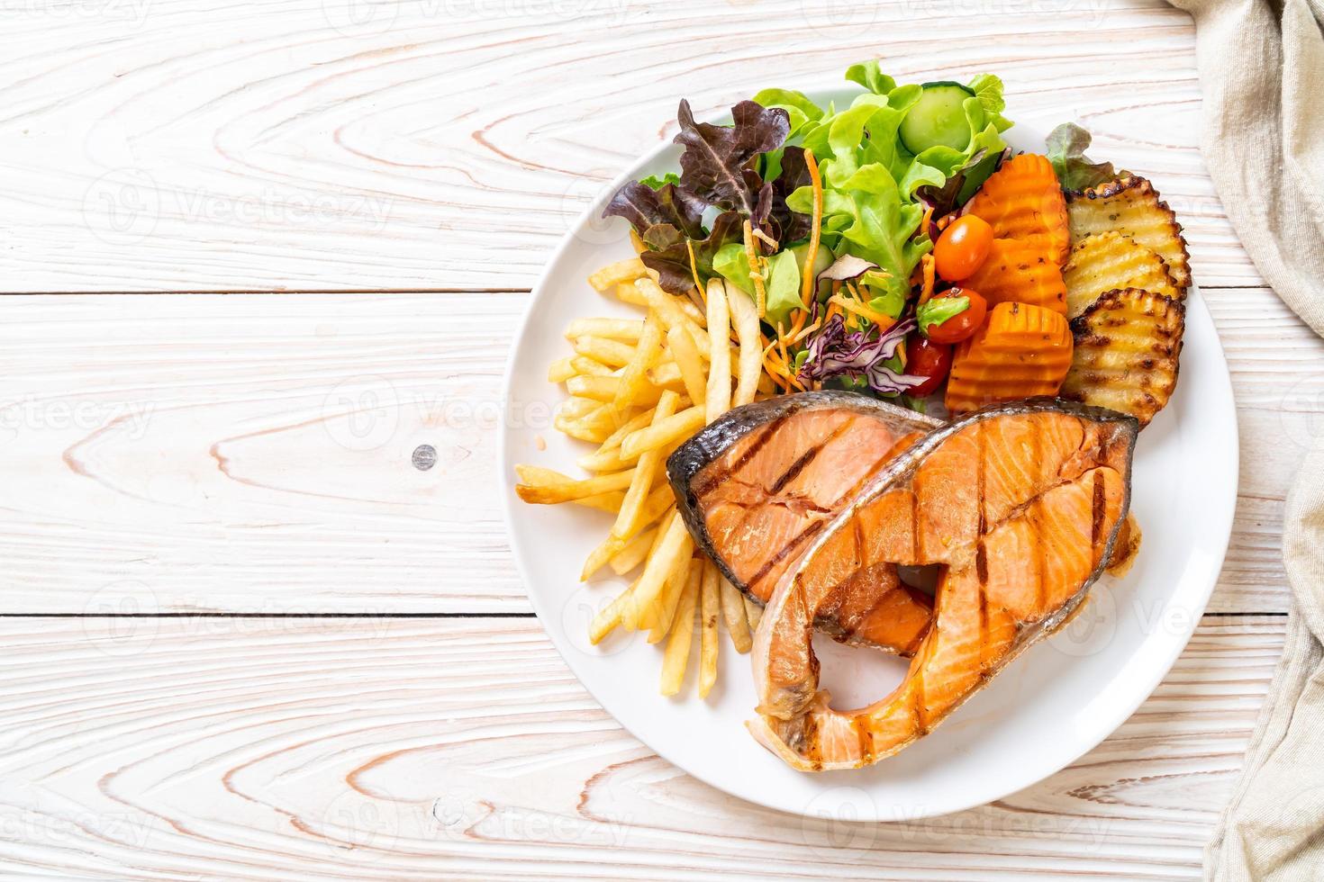 grilled salmon steak fillet with vegetable and french fries photo