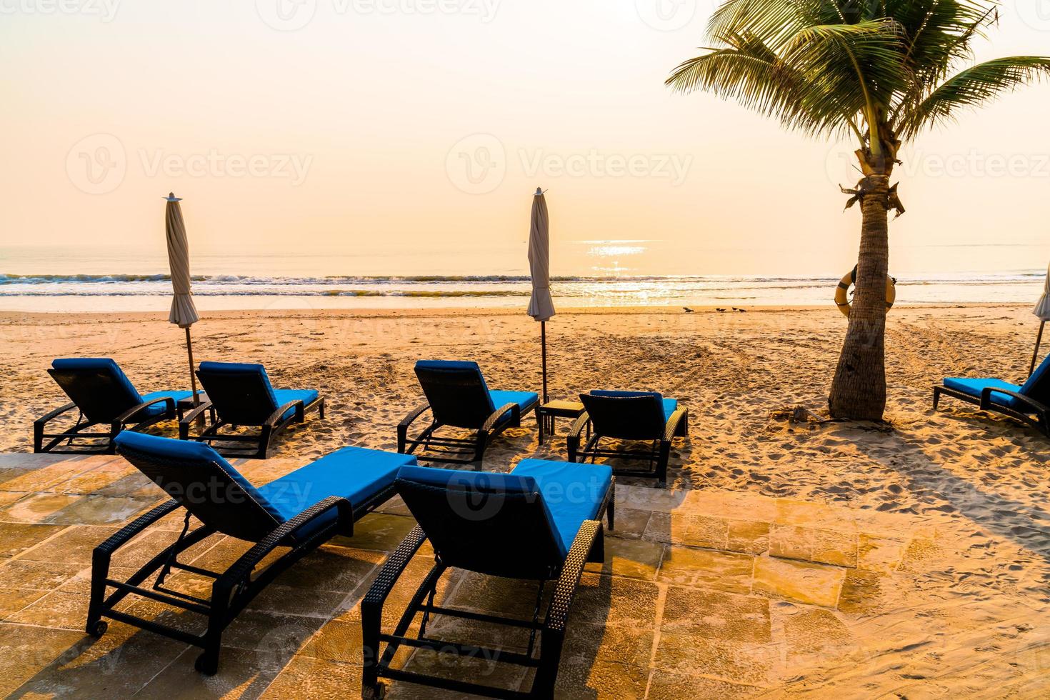 umbrella chair beach with palm tree and sea beach at sunrise times photo