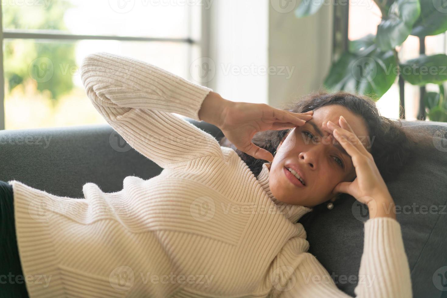 mujer latina, acostado, en, sofá, con, dolor de cabeza, sentimiento foto