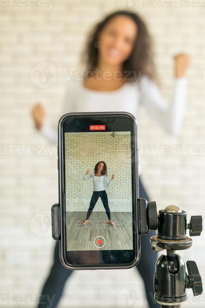 Latin woman created her dancing video by smartphone camera. To share video to social media application. photo