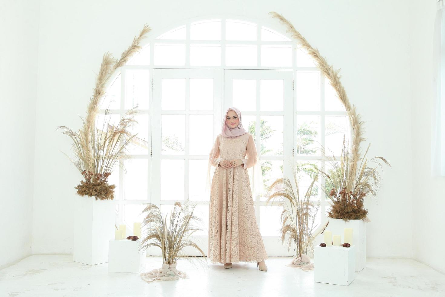 Retrato de cuerpo entero de dama con vestido de novia, maquillaje de boda en hijab. vestido de novia malayo o indonesia, concepto de belleza o eidul fitri. Hermosa mujer musulmana del sudeste asiático posando en traje de islam foto