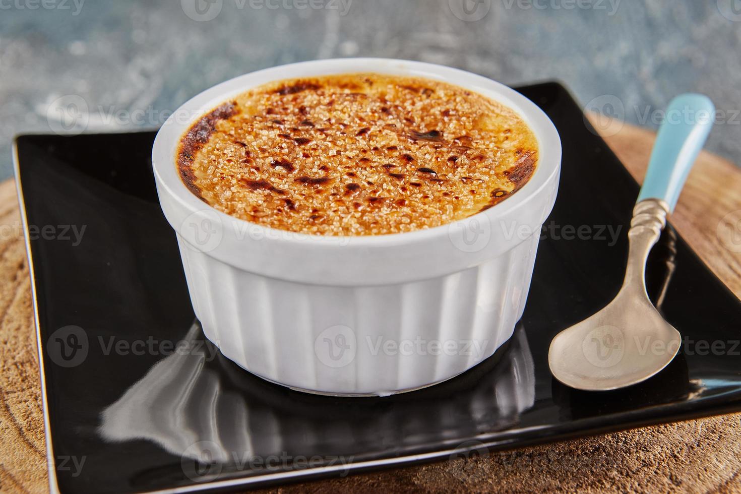 Creme brulee with mushrooms in special form on plate with spoon photo