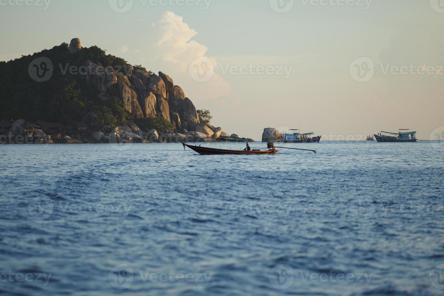 longtail boat floating over blue sea of koh tao island thailand photo