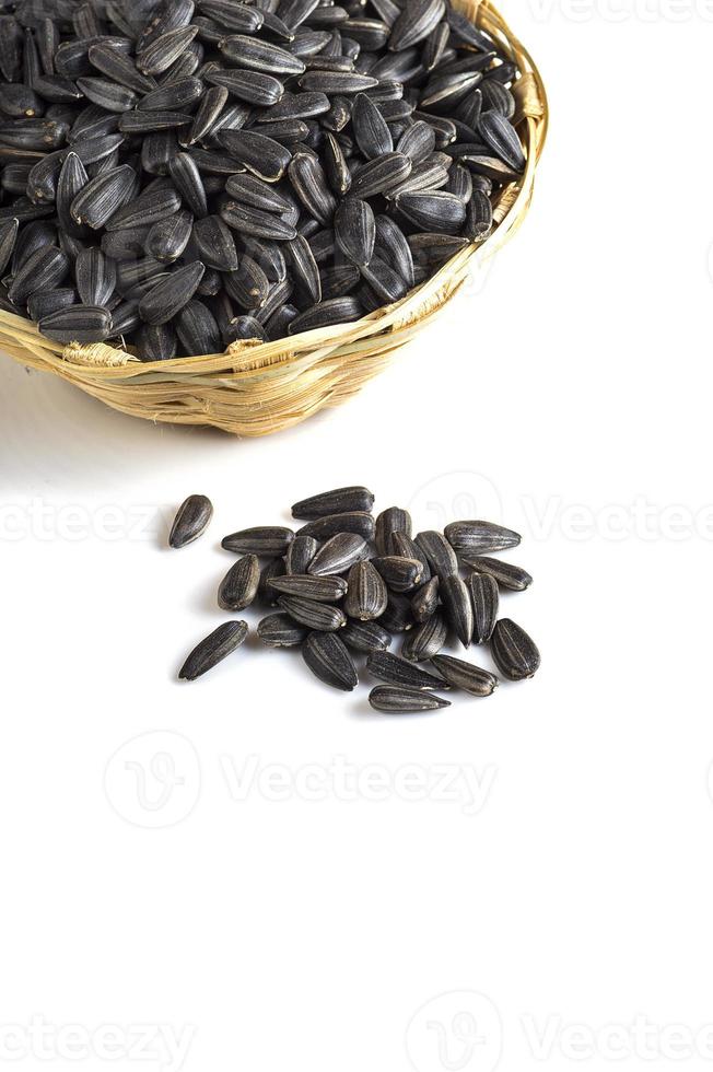 Sunflower Seeds in wooden basket on white background. Helianthus annuus. photo