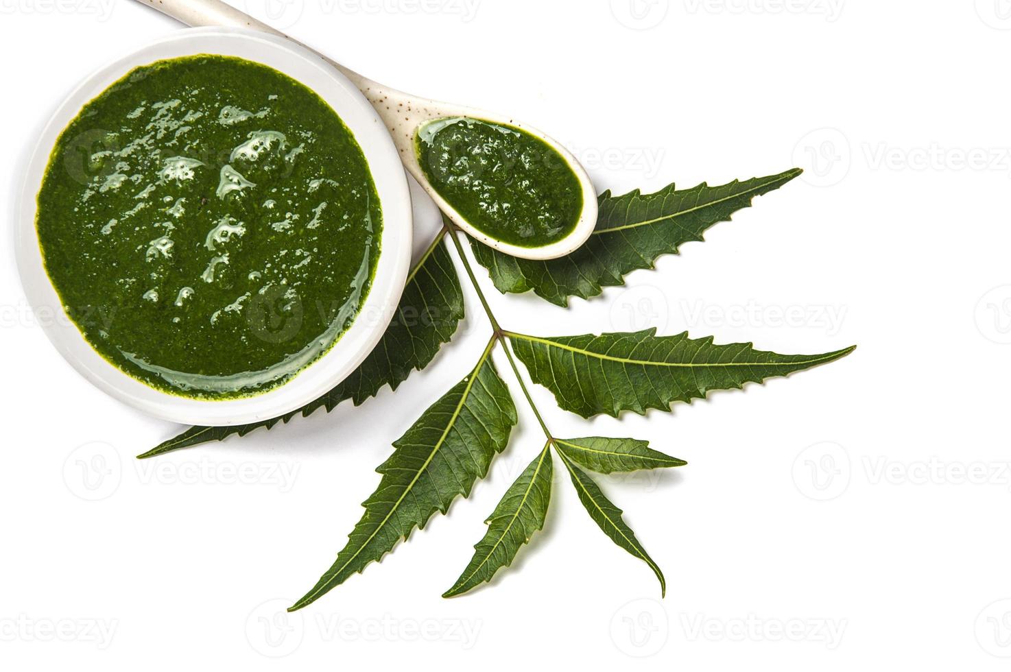 Medicinal Neem leaves with neem paste in spoon and plate on white background Azadirachta indica photo