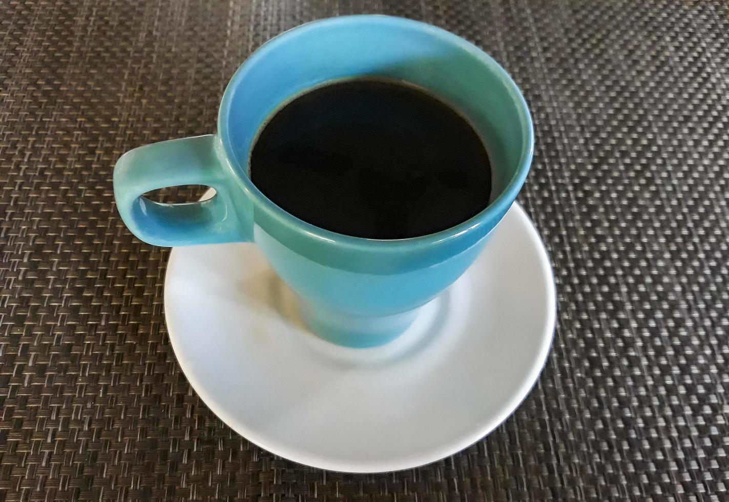 Taza azul de olla con café negro en Mallorca, España. foto