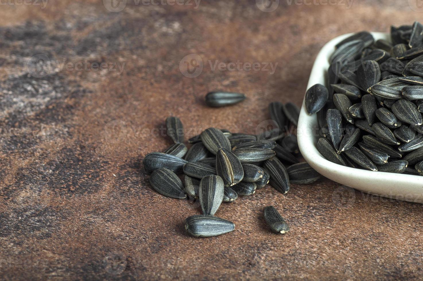 Sunflower Seeds, Helianthus annuus in white on stone background. photo