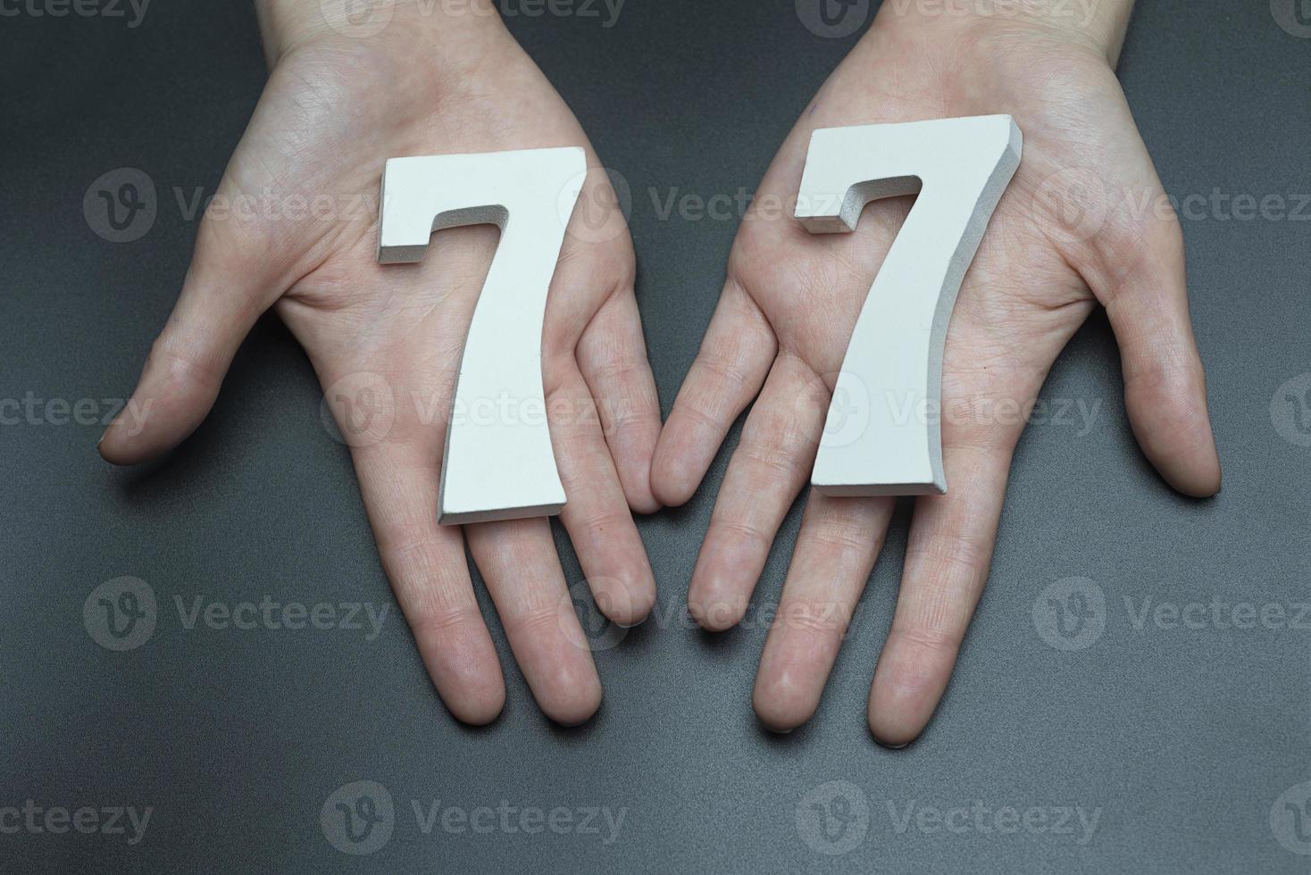 To female hands the figure of seventy-seven. photo