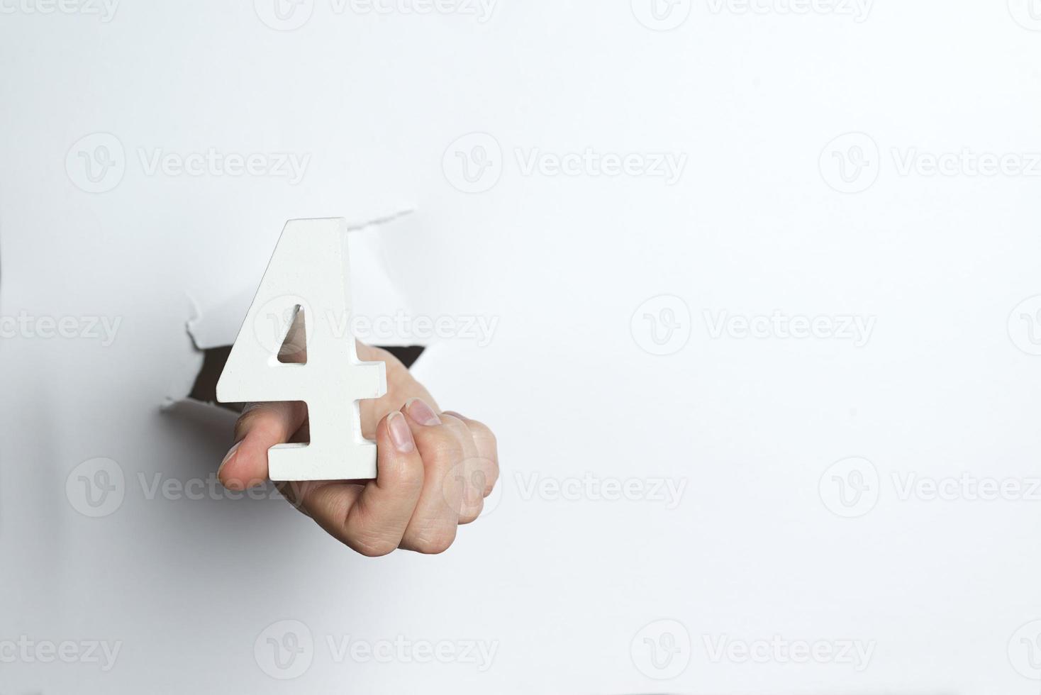 mano femenina sosteniendo un fondo blanco de cuatro dígitos. foto