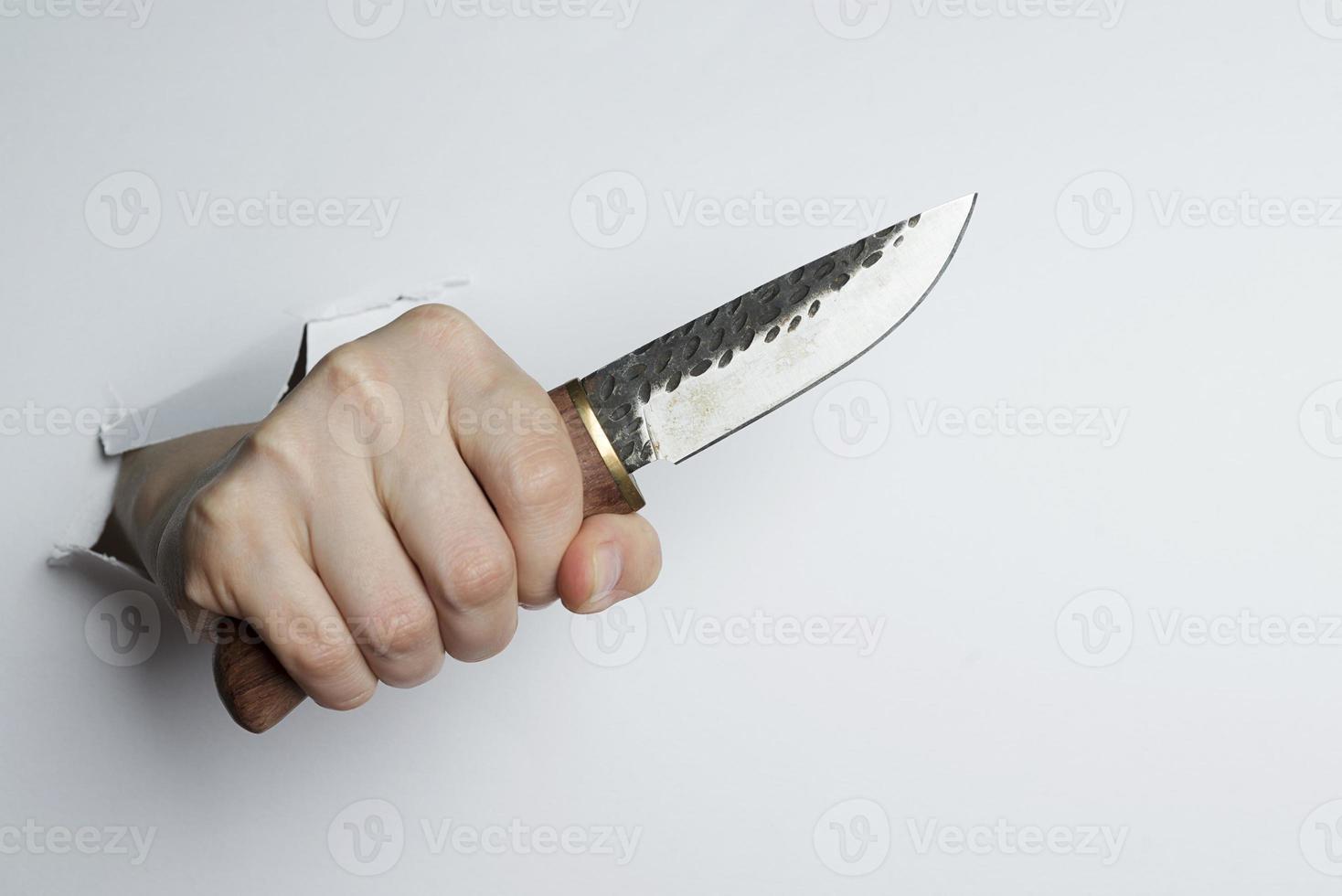 Female hand holding a knife on white background. photo