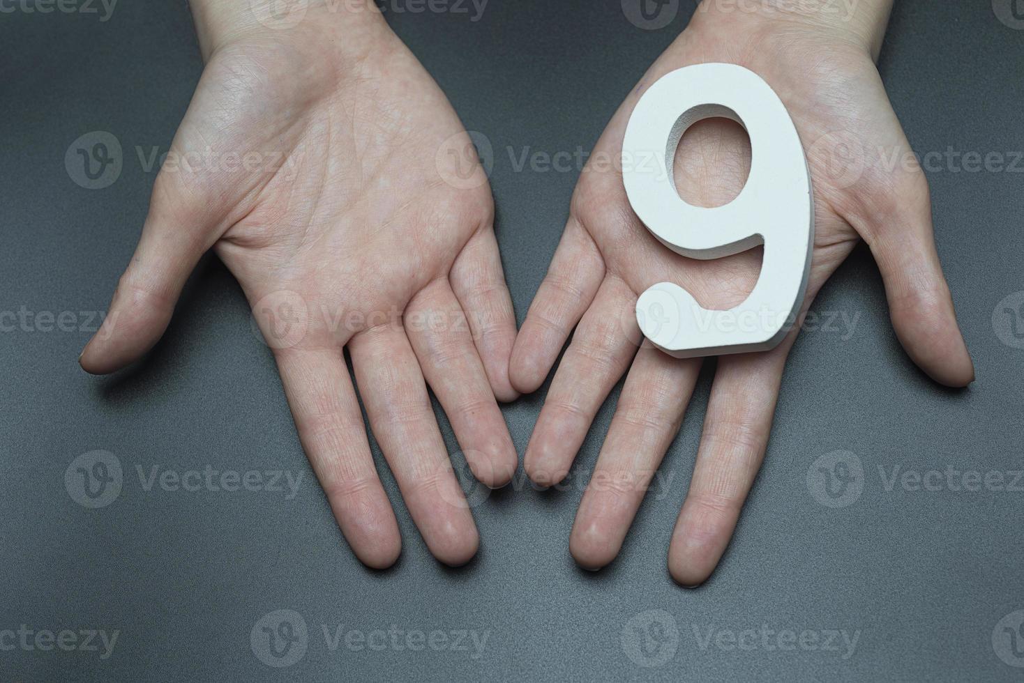 a manos femeninas el número nueve. foto