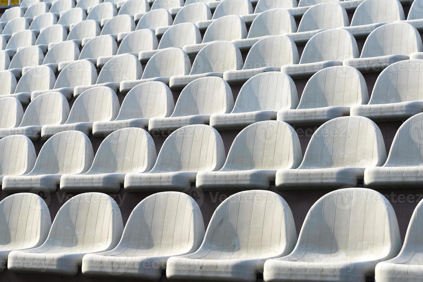 Gray chairs in the stands of the arena. photo