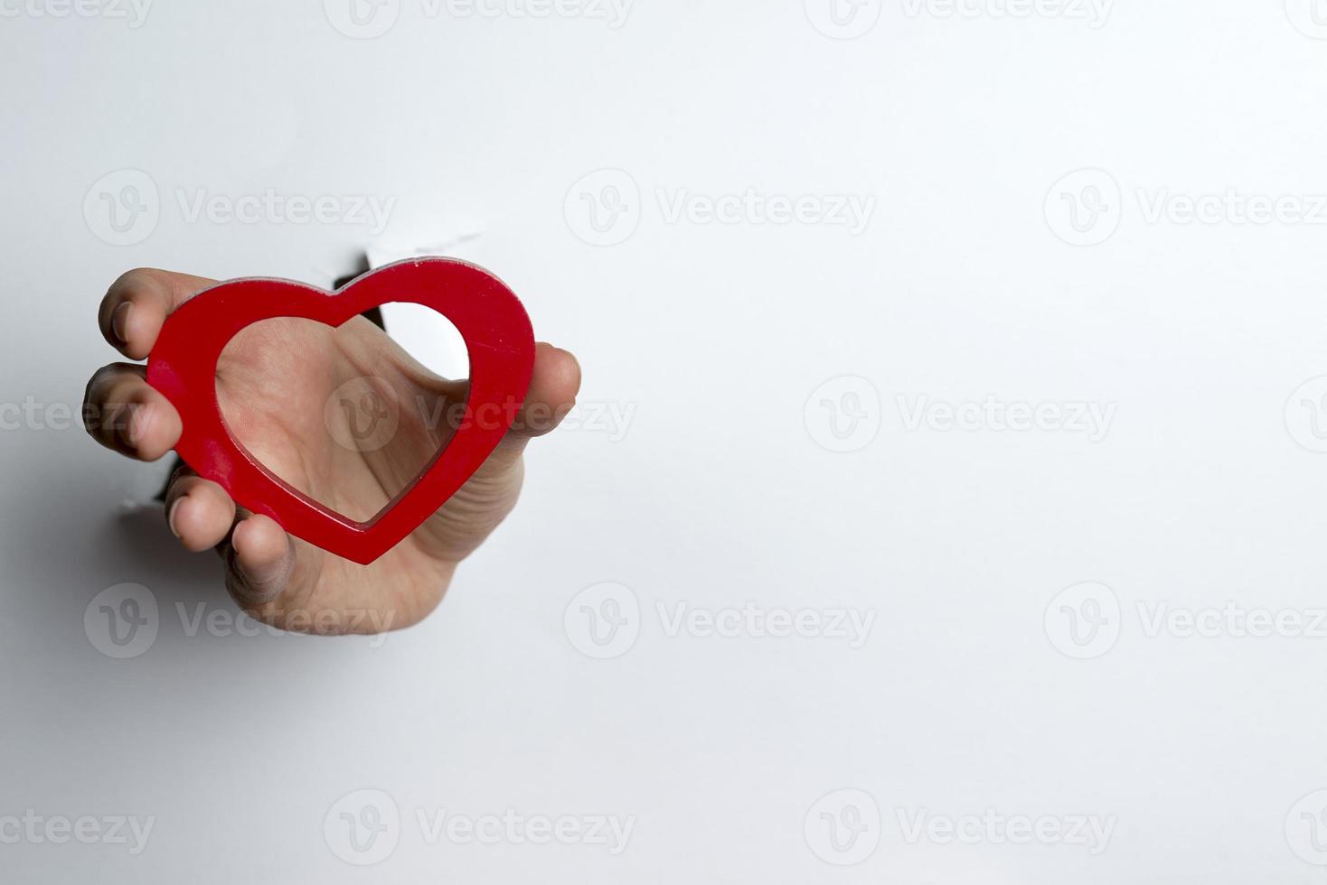 Female hand holding a heart on a white background. photo