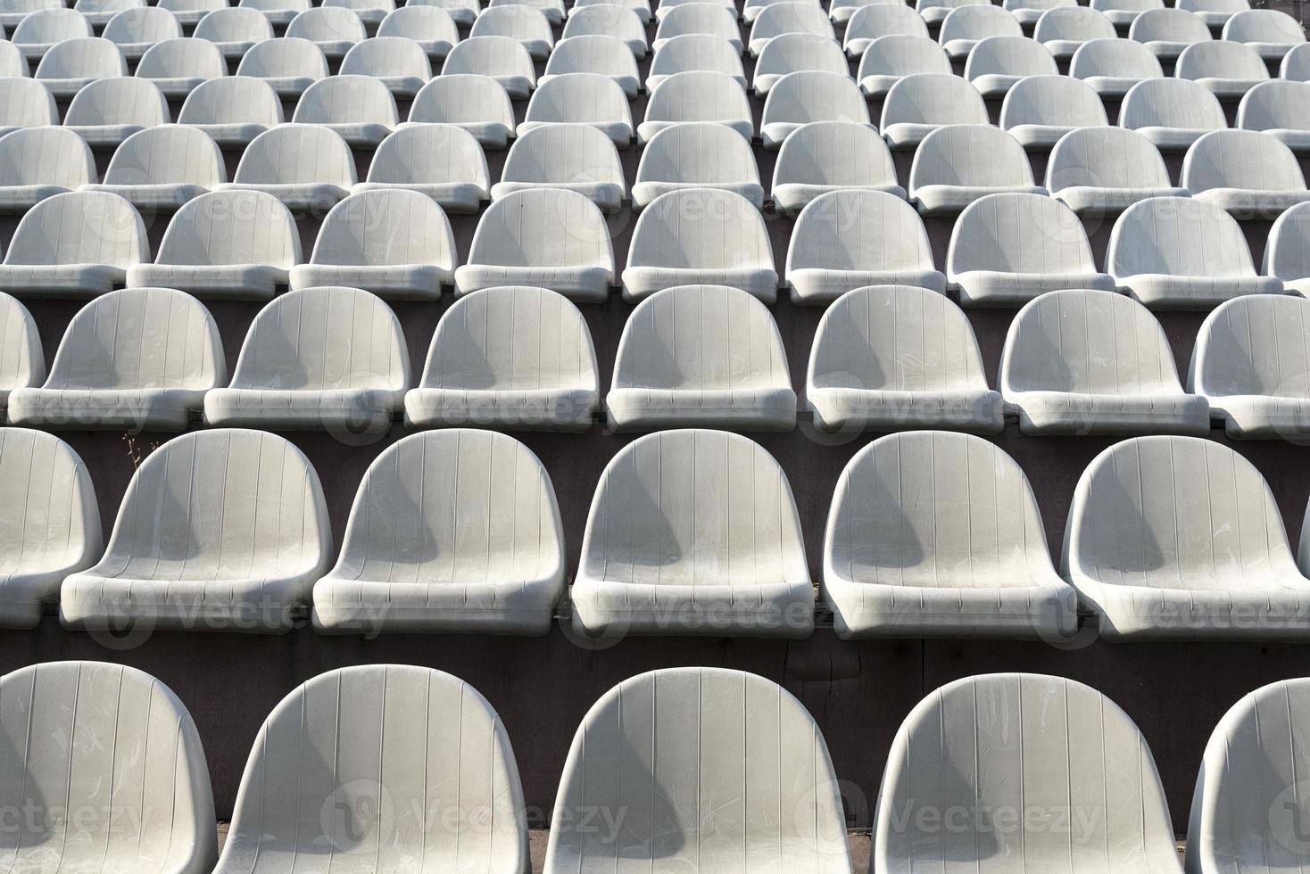 Gray chairs in the stands of the arena. photo