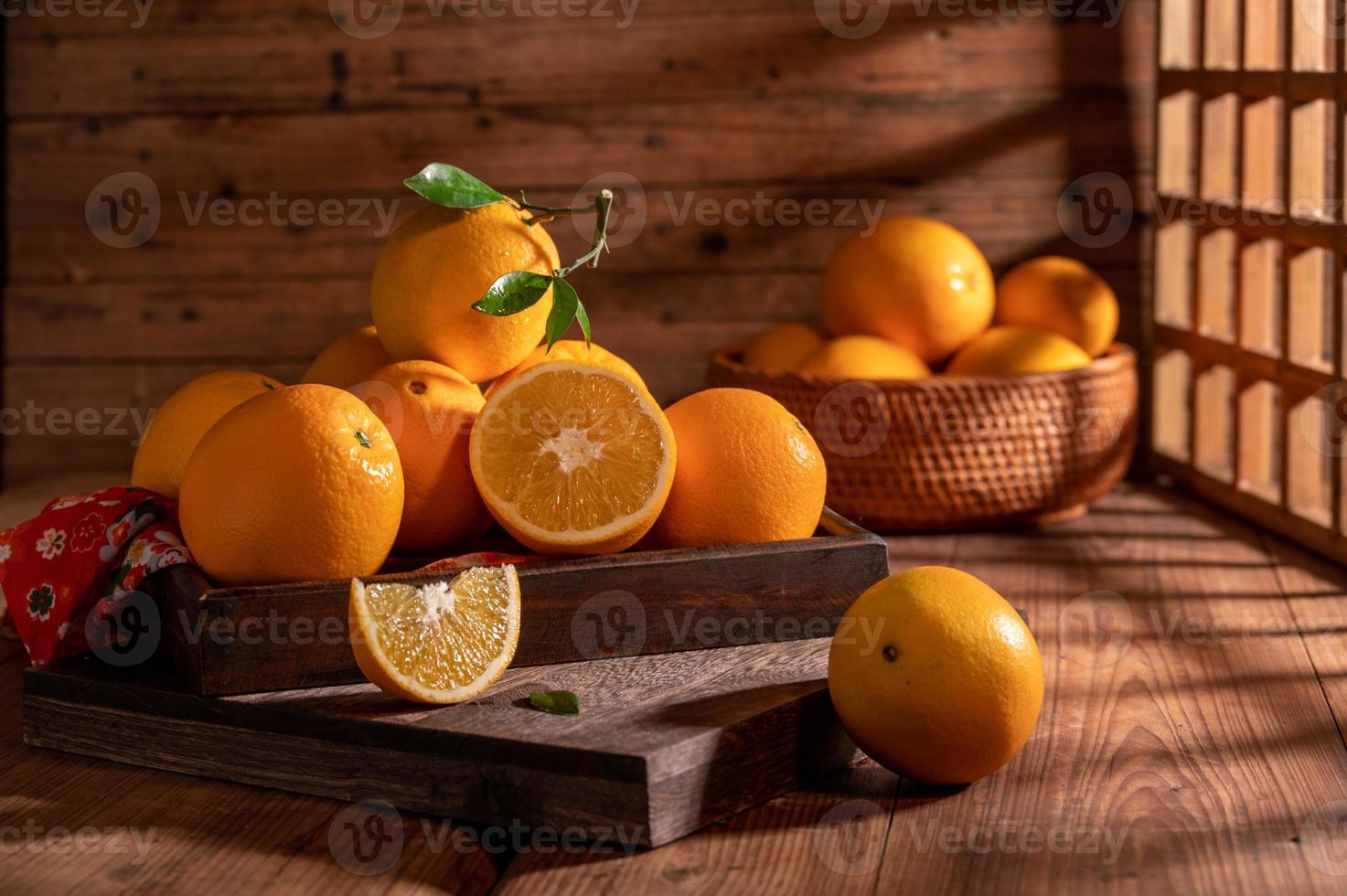 bajo la luz tenue, las naranjas en el plato están sobre la mesa de madera, como pinturas al óleo foto