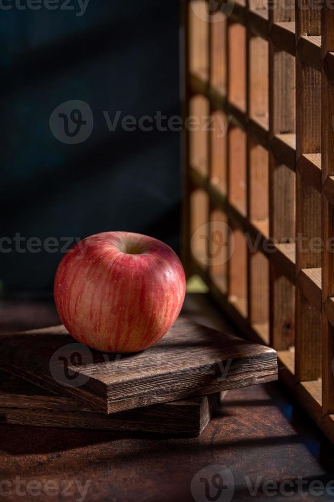 las manzanas en el plato parecen pinturas al óleo bajo la luz tenue de la mesa de madera foto