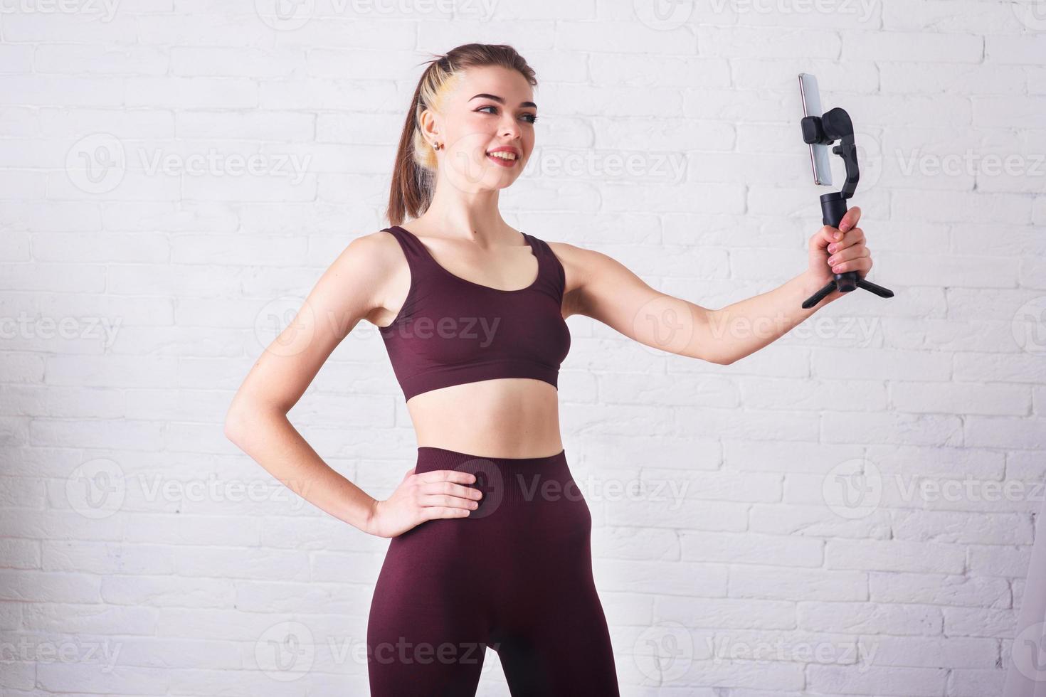 la chica se dedica al fitness en casa. Entrenamiento interactivo por video chat. ocupación deportiva en línea foto