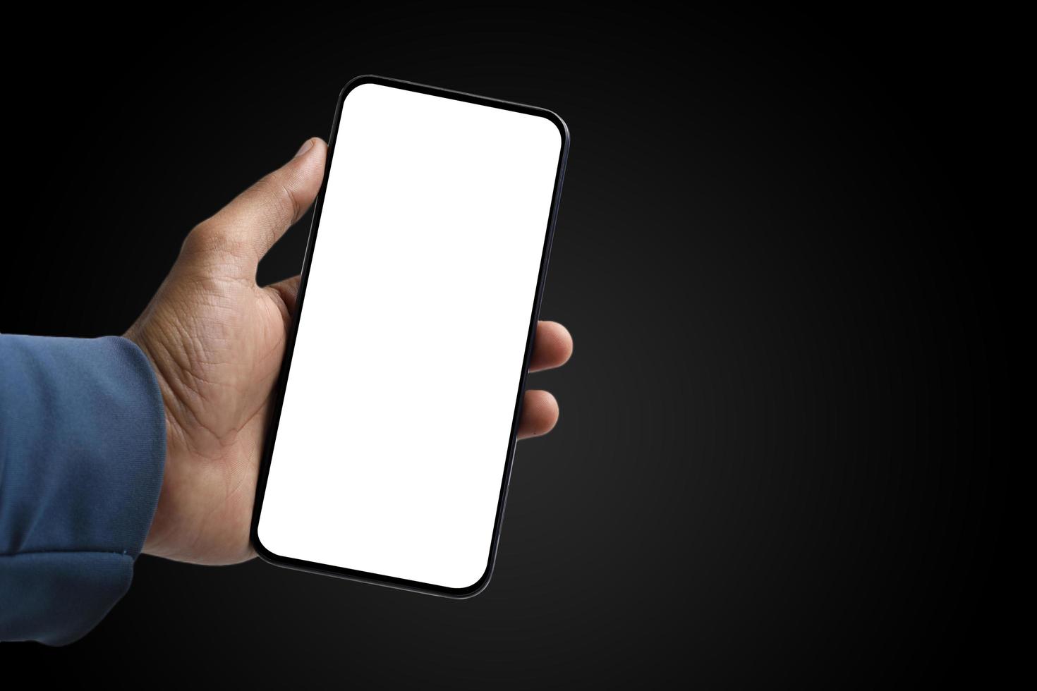 holding smartphone in hand on dark background photo