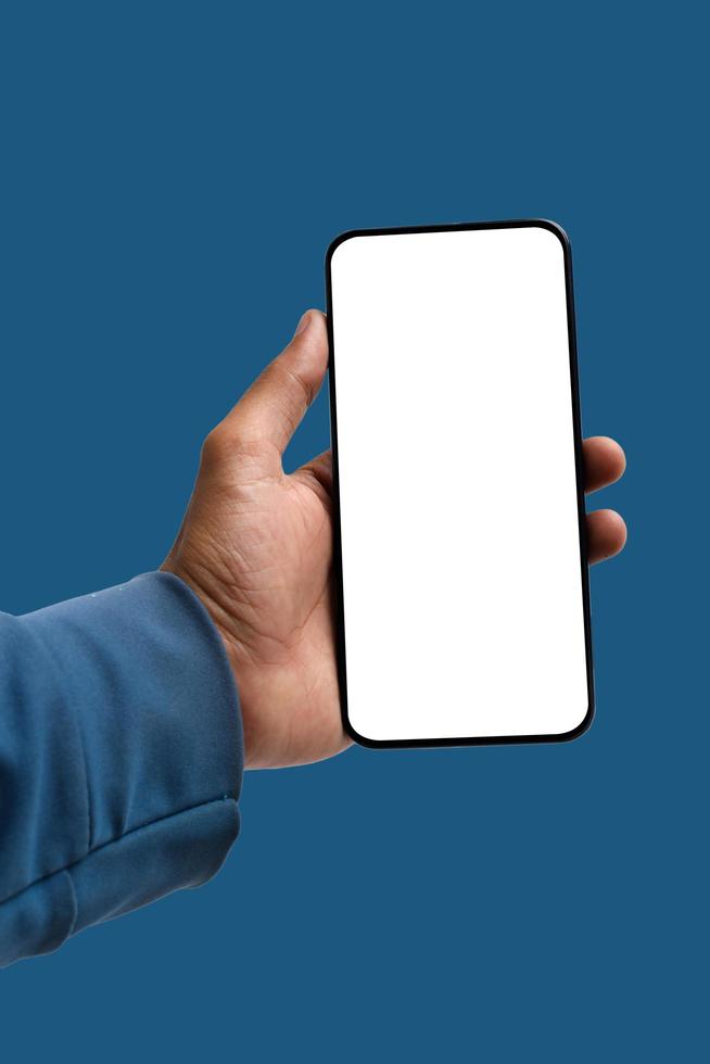 holding smartphone in hand on blue background photo