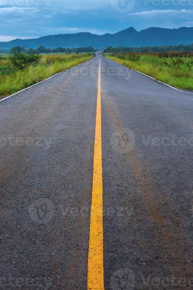 transporte por carretera sinuosa que va a la distancia con un dibujo de línea amarilla separado en dos sentidos hacia adelante y hacia atrás, foto