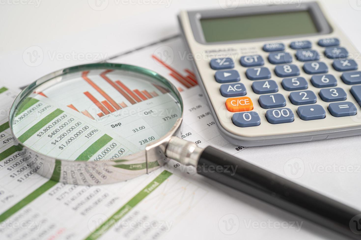 Magnifying glass and calculator on charts graphs paper. Financial development, Banking Account, Statistics, Investment Analytic research data economy, Stock exchange trading, Business office concept. photo