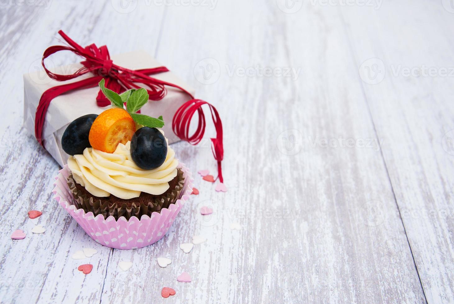 Cupcakes with fresh berries and gift box photo