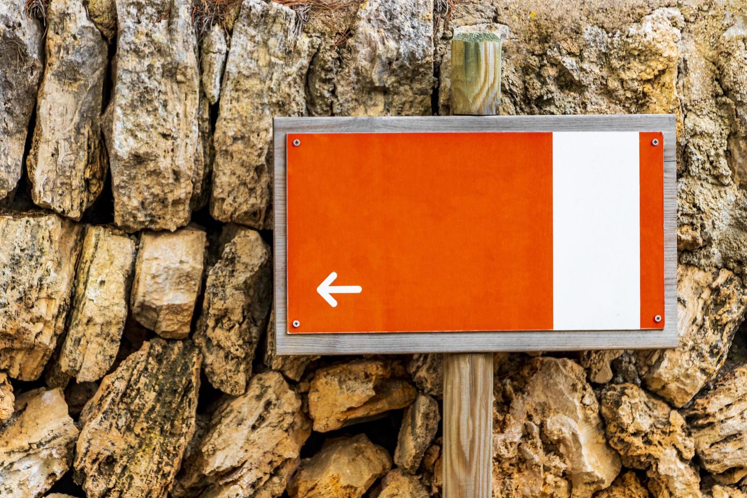 Orange white wooden sign with directional arrow photo