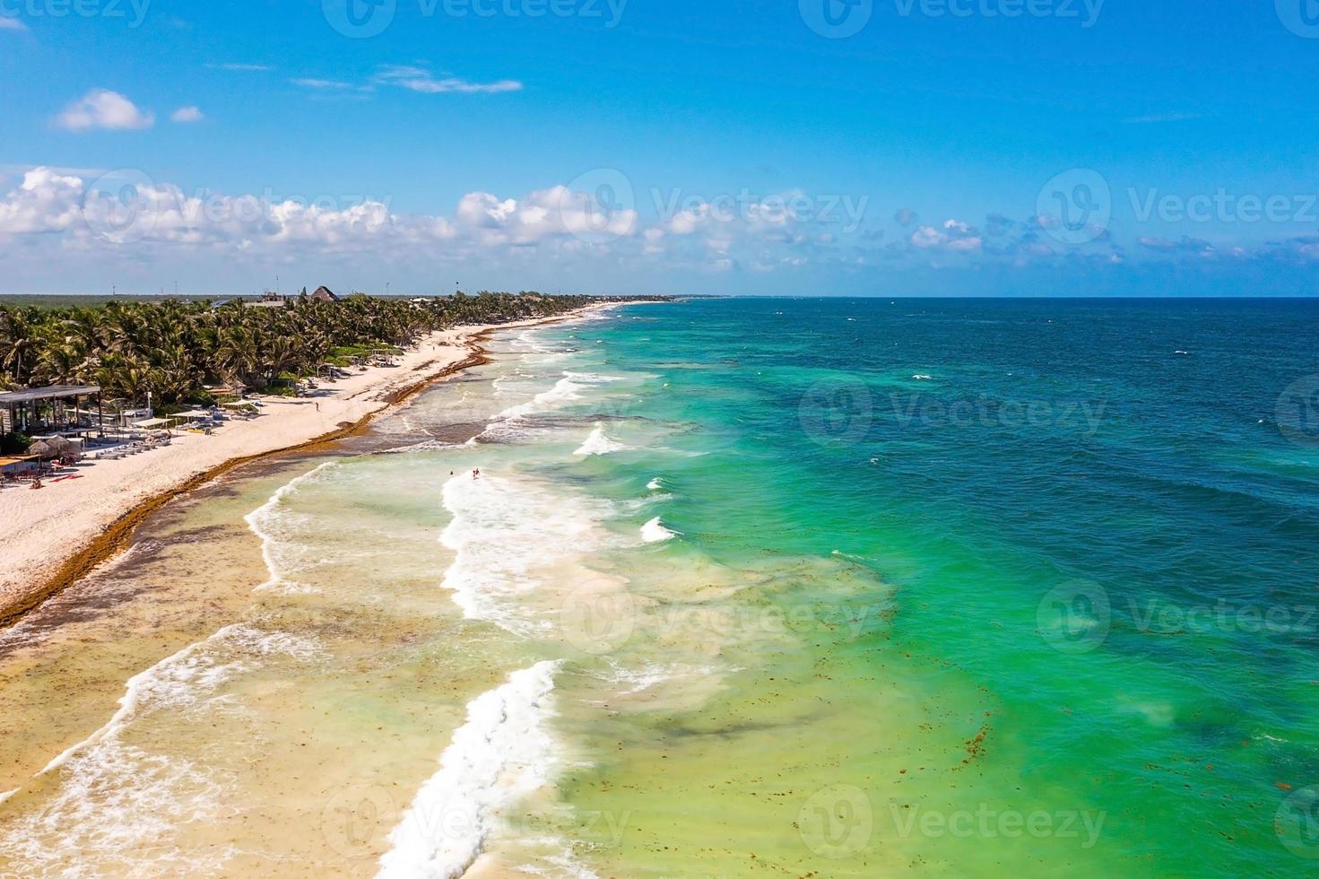 Aerial Tulum coastline by the beach with a magical Caribbean sea and small huts by the coast. photo