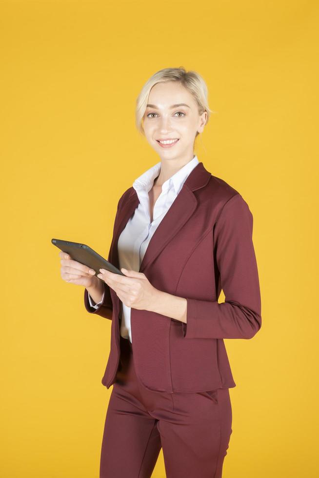 mujer de negocios está usando tableta en estudio fondo amarillo foto