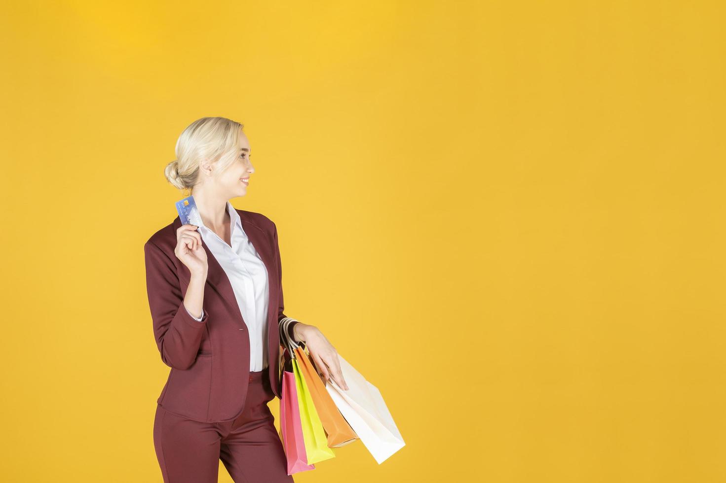 la mujer de negocios está feliz con las compras en el fondo amarillo del estudio foto