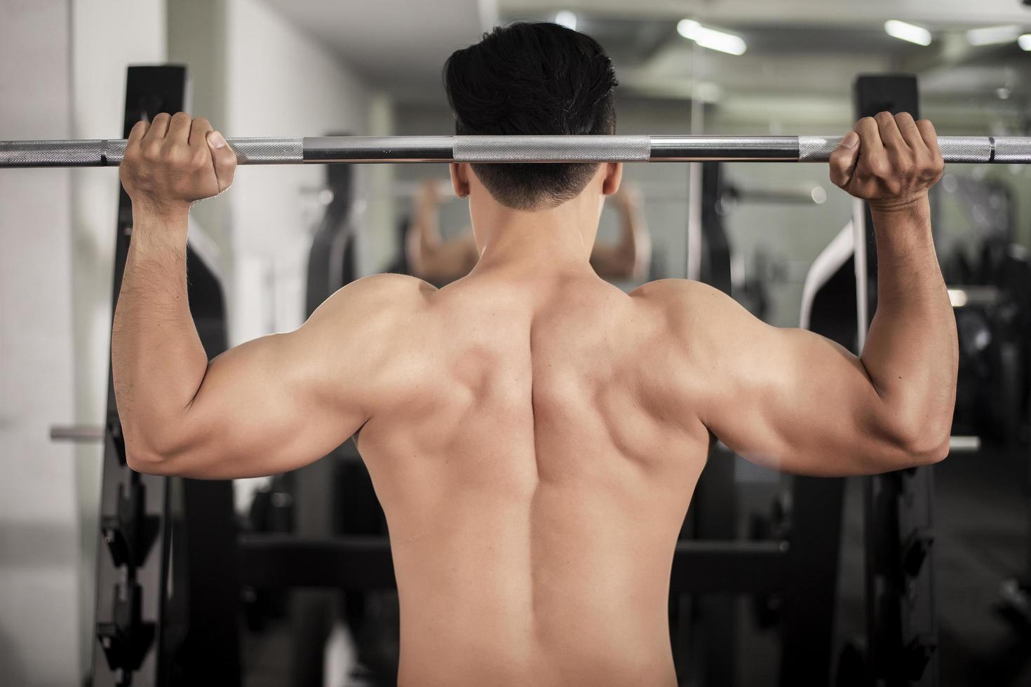 hombre culturista con gran espalda muscular en el gimnasio foto