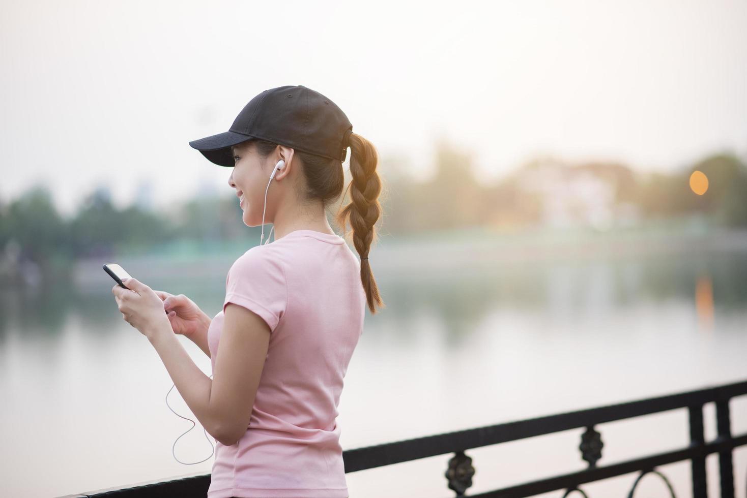 hermosa mujer está escuchando música en el parque foto