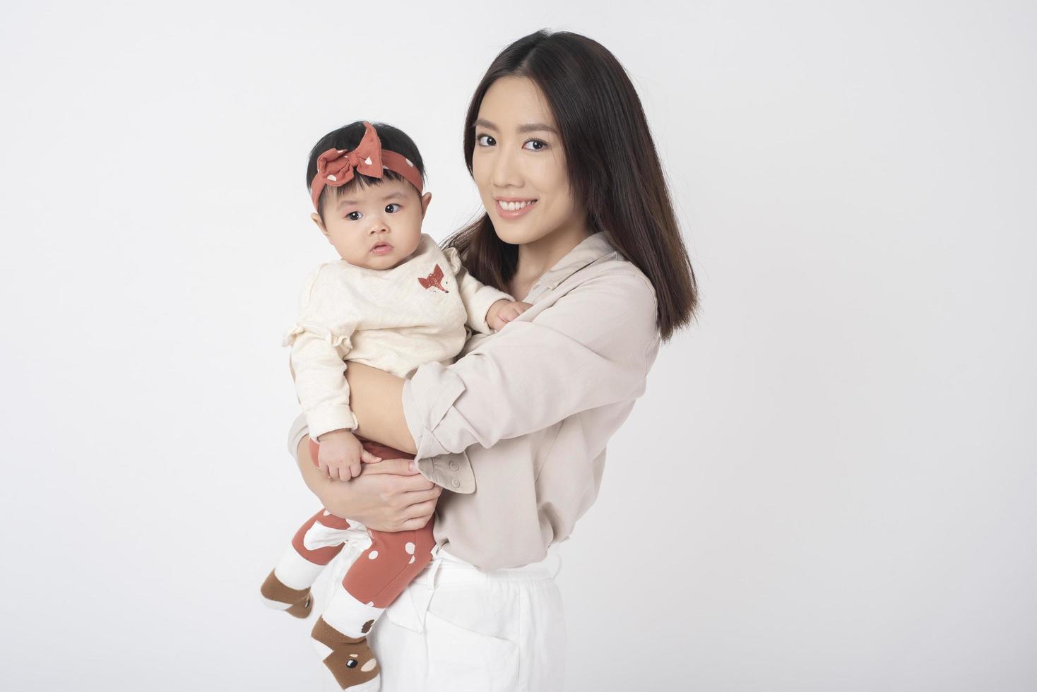 Asian mother and adorable baby girl are  happy on white background photo