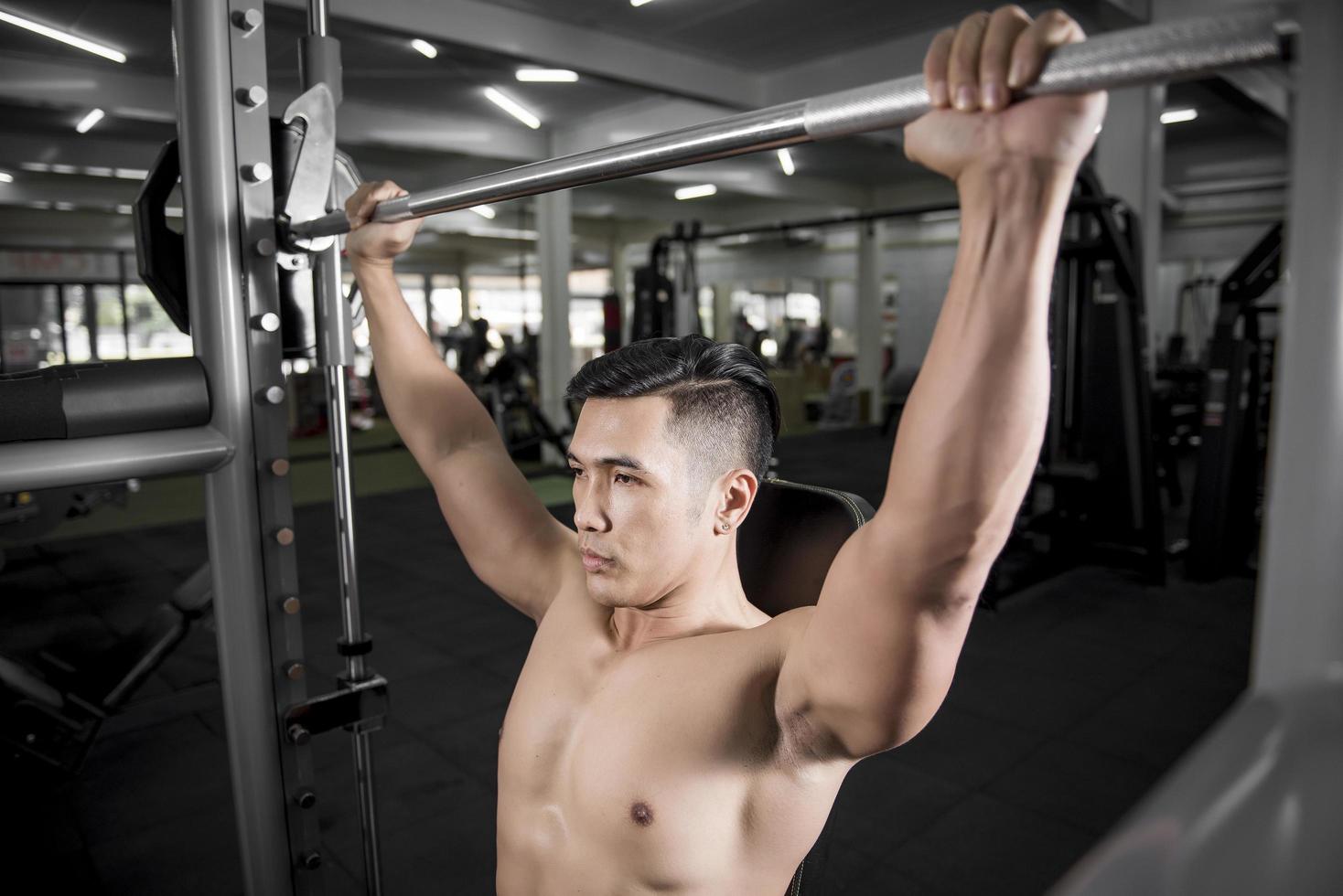 Muscular fitness hombre culturista está entrenando en el gimnasio foto