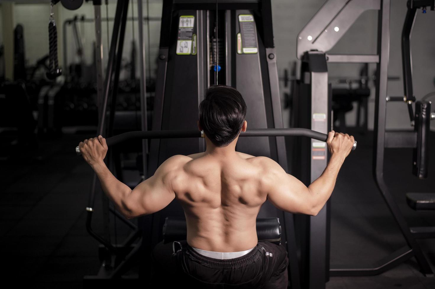 Bodybuilder man with big muscular  back in the gym photo