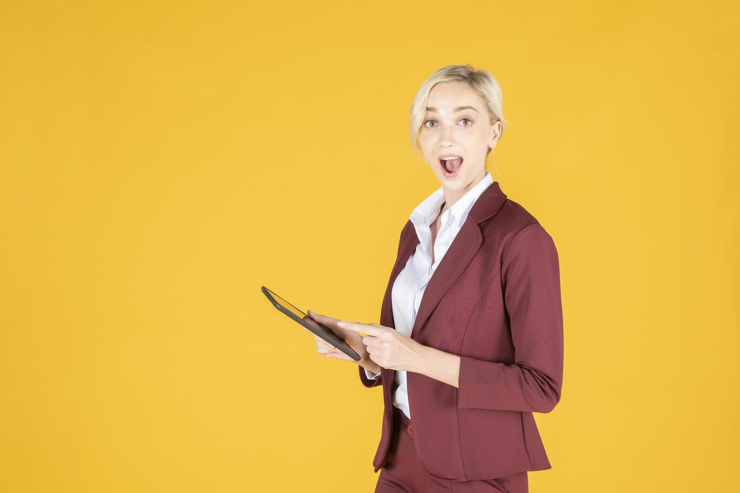 mujer de negocios es sorprendente en estudio de fondo amarillo foto