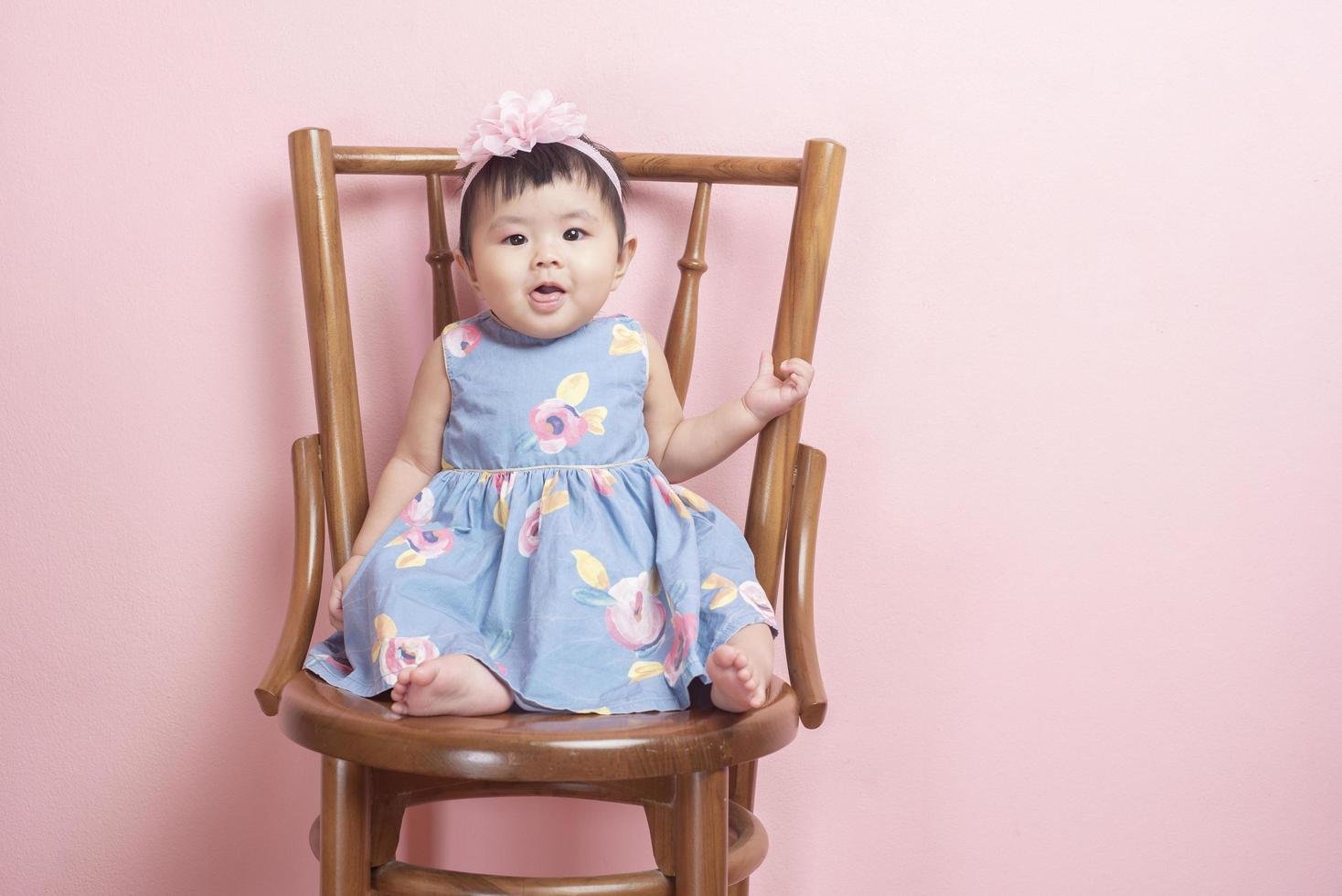 adorable niña asiática es un retrato de fondo rosa foto