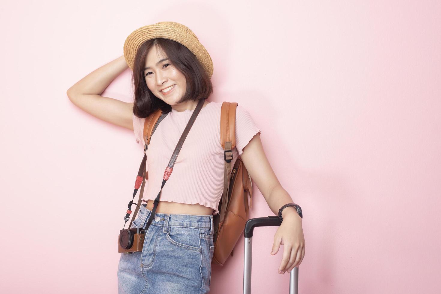 mujer asiática feliz turista sobre fondo rosa foto