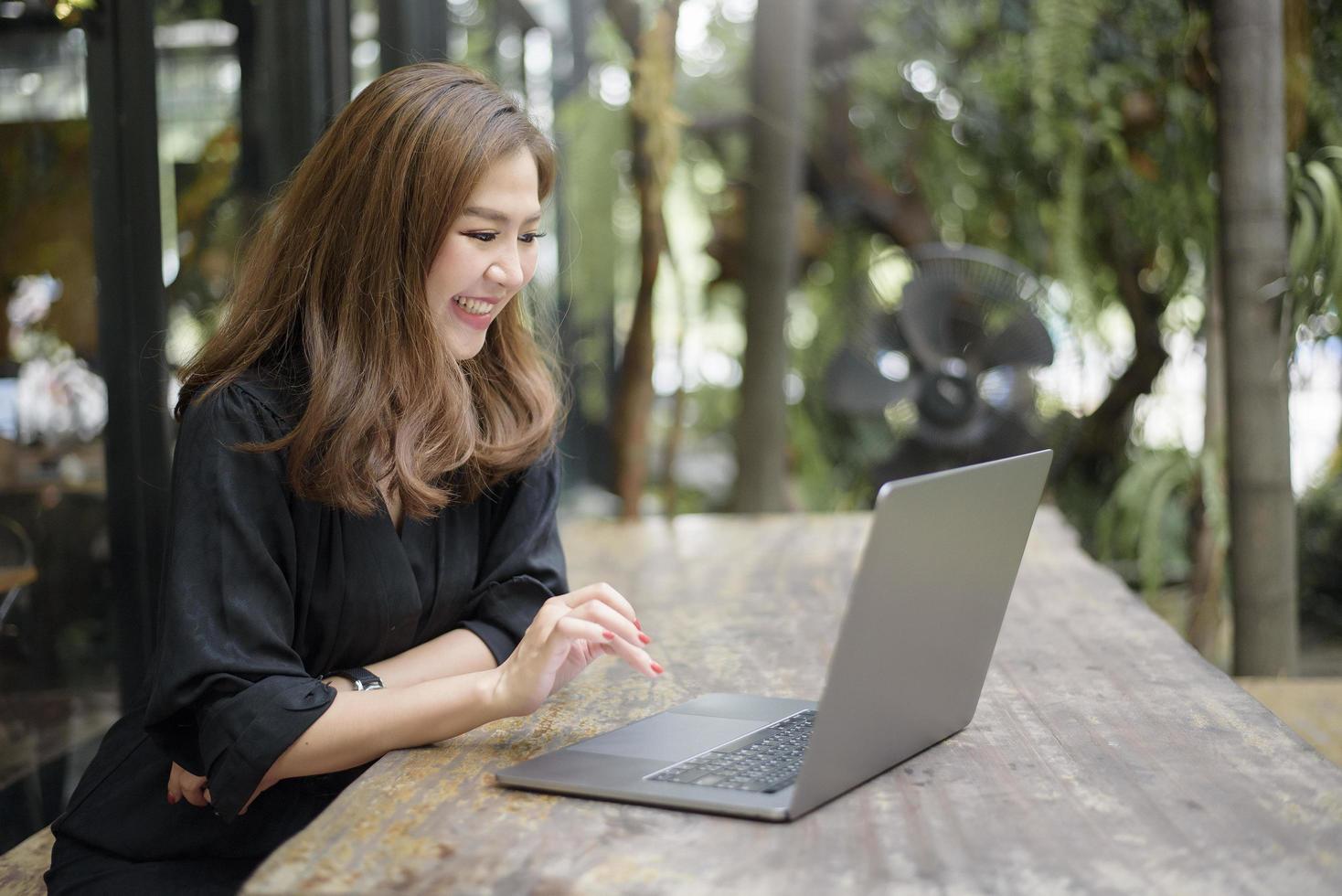 Smart Asian female is working with laptop computer photo