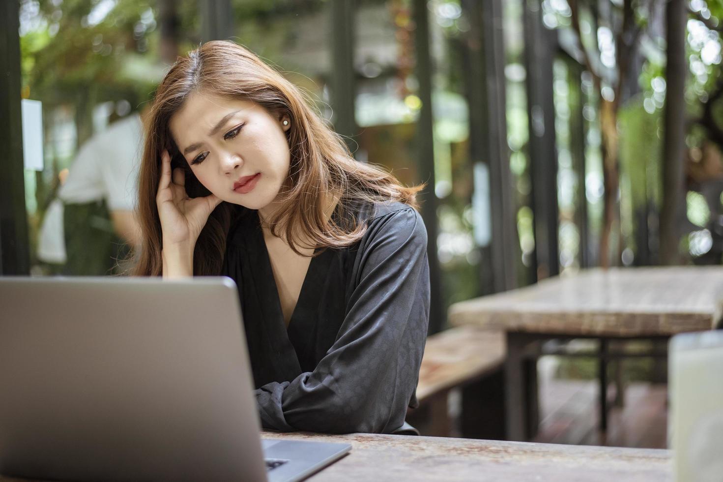 Stressed Asian woman feeling headache  in cafe shop photo