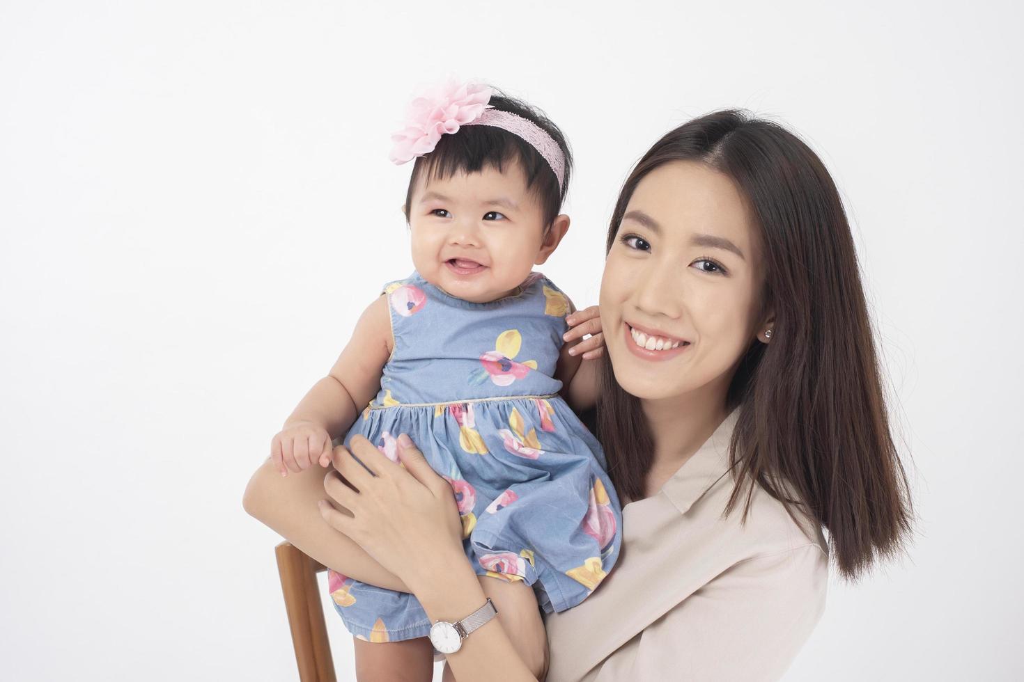 Asian mother and adorable baby girl are  happy on white background photo