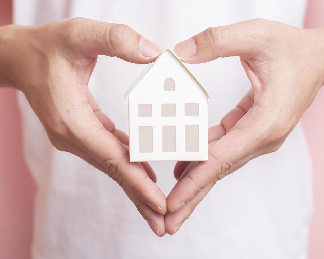 Small white house on human hand photo