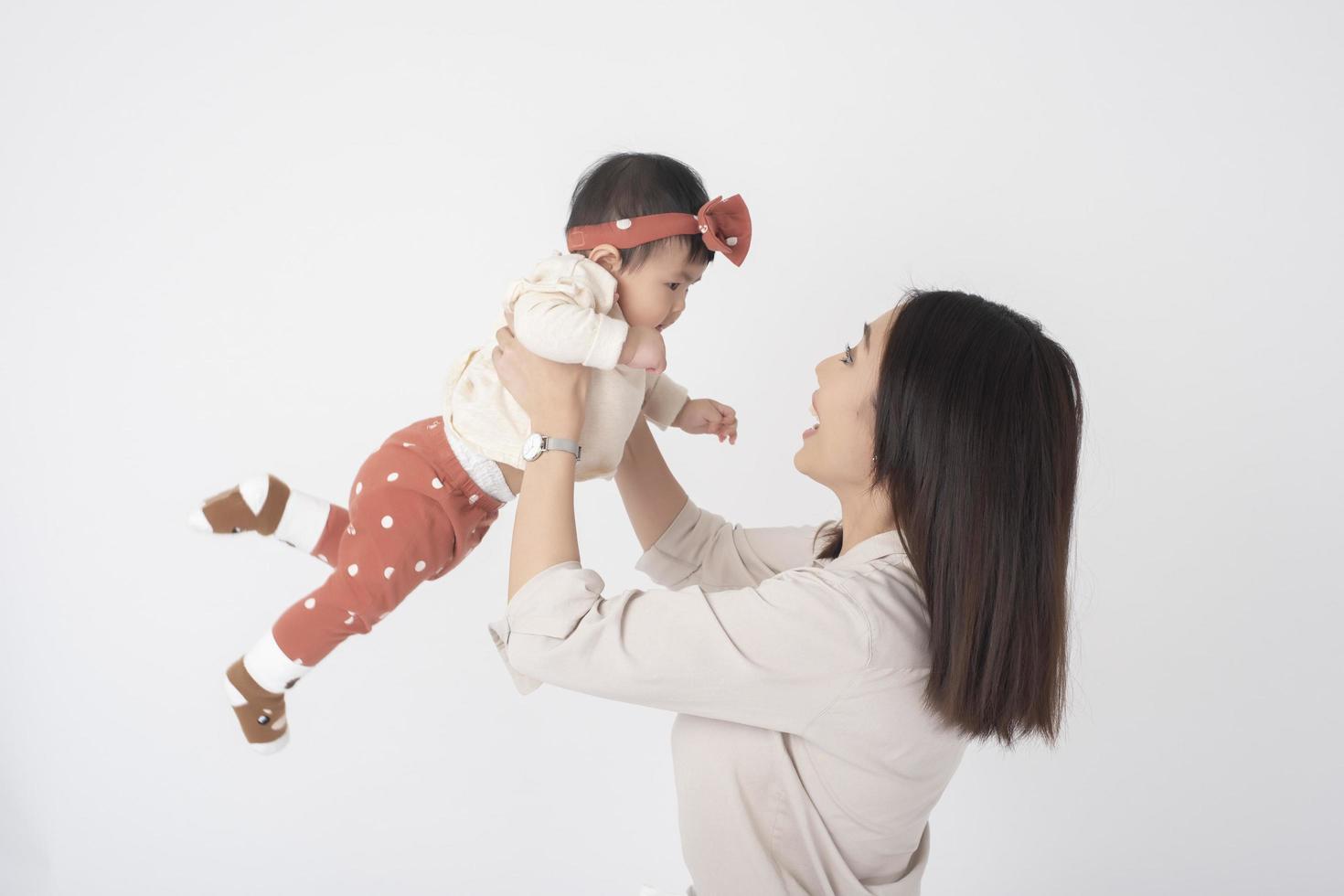 Asian mother and adorable baby girl are  happy on white background photo