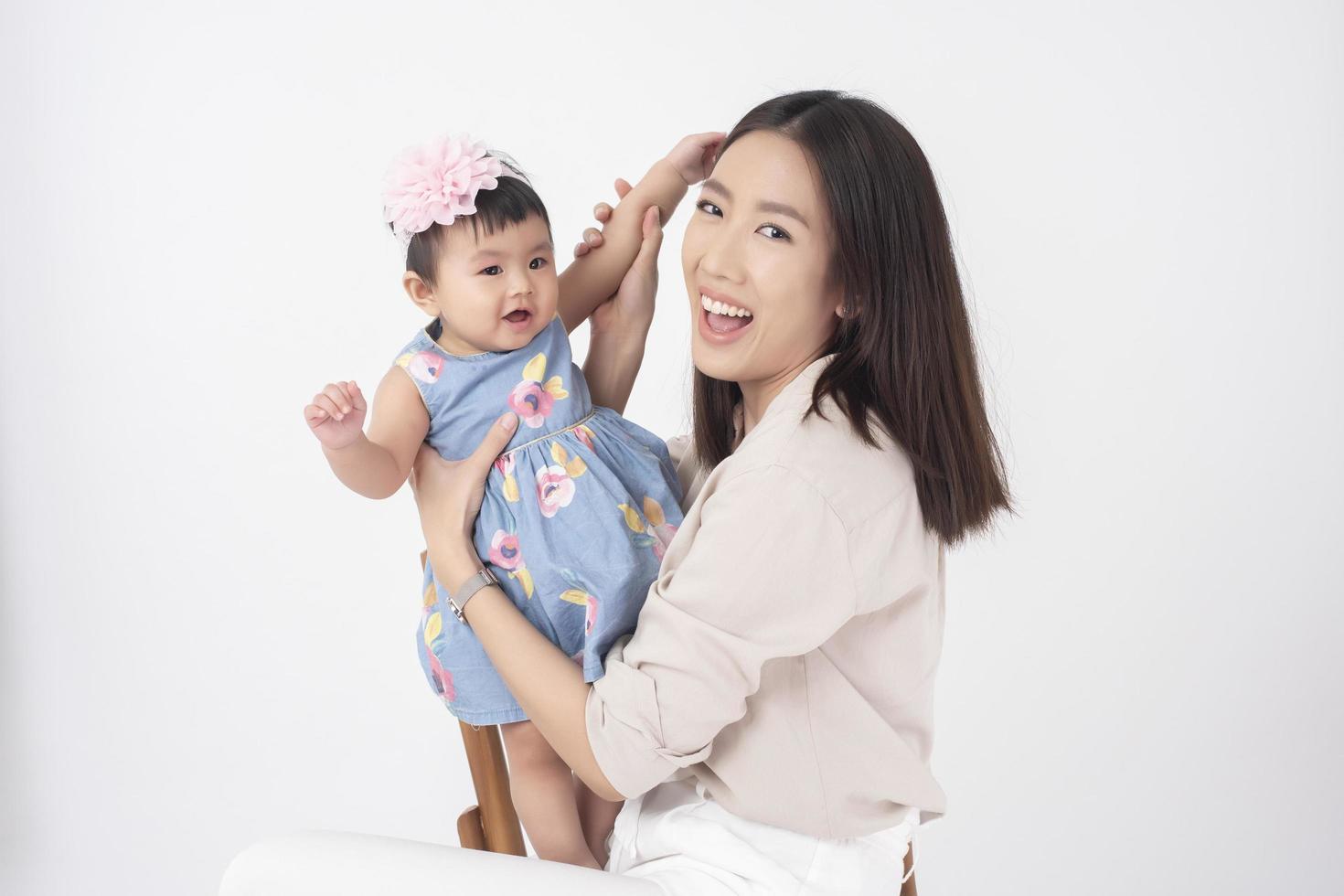 Asian mother and adorable baby girl are  happy on white background photo