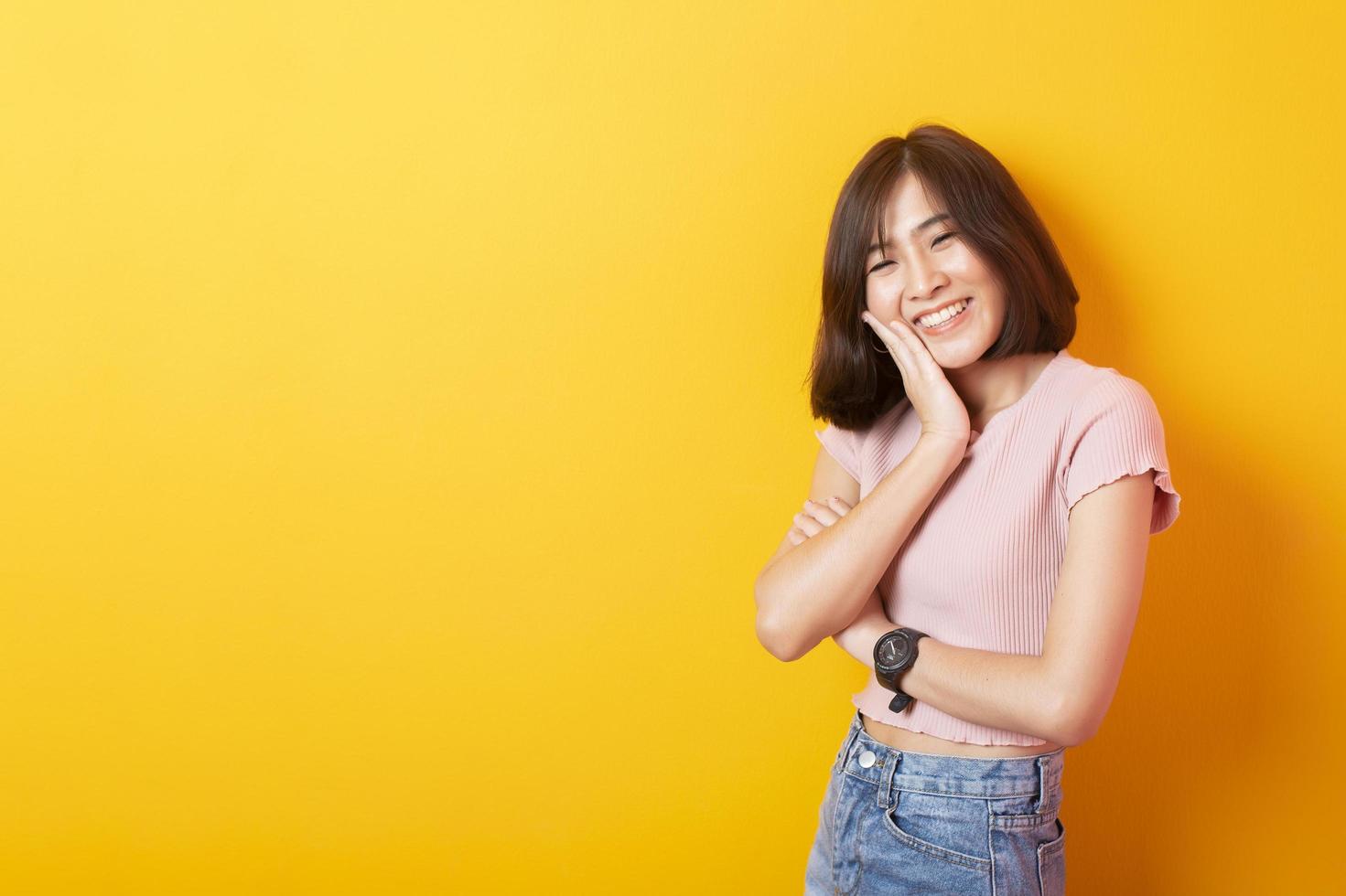 bella estudiante universitaria asiática feliz con antecedentes amarillos foto