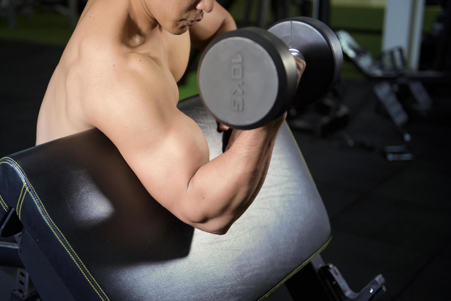 El fisicoculturista de fitness muscular está entrenando con pesas en el gimnasio foto